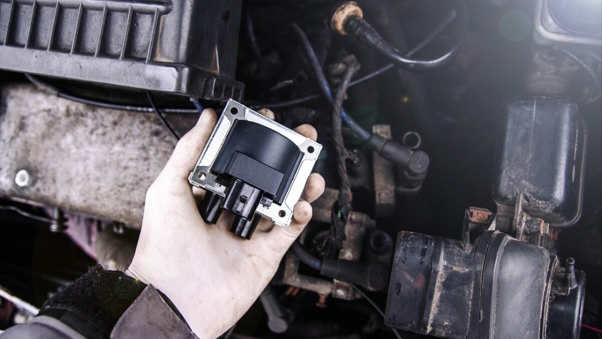 Auto mechanic changing a speed sensor in the engine crankshaft