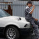 man sitting on a junk car