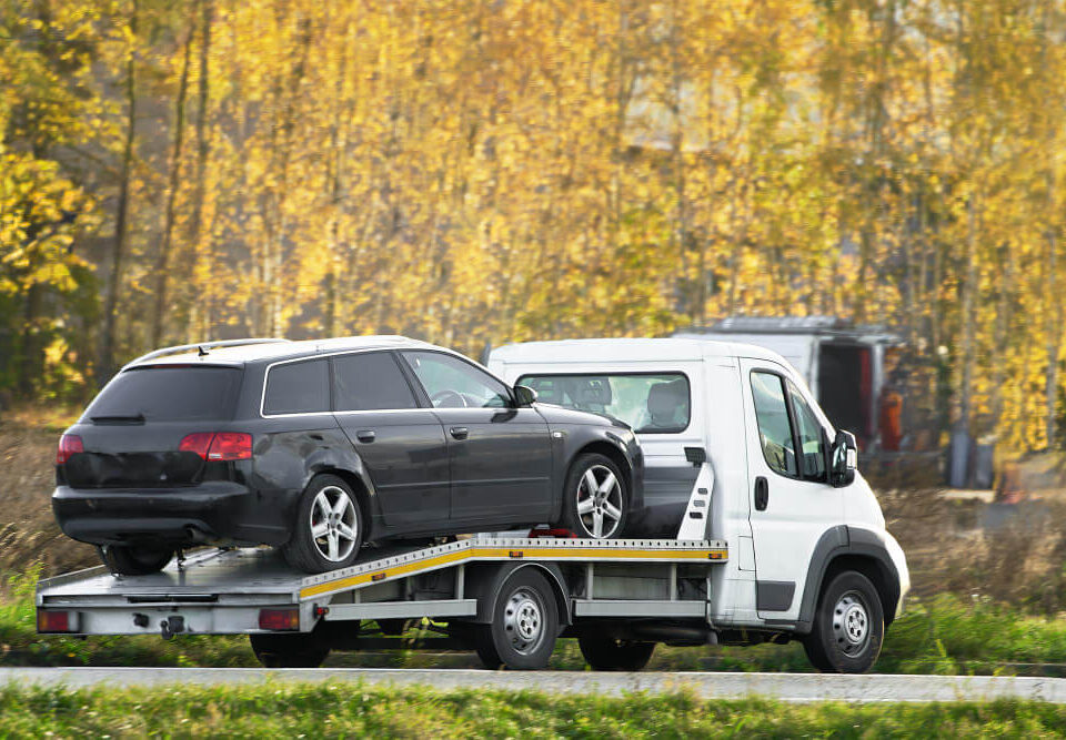 black car on a flatbed tow truick
